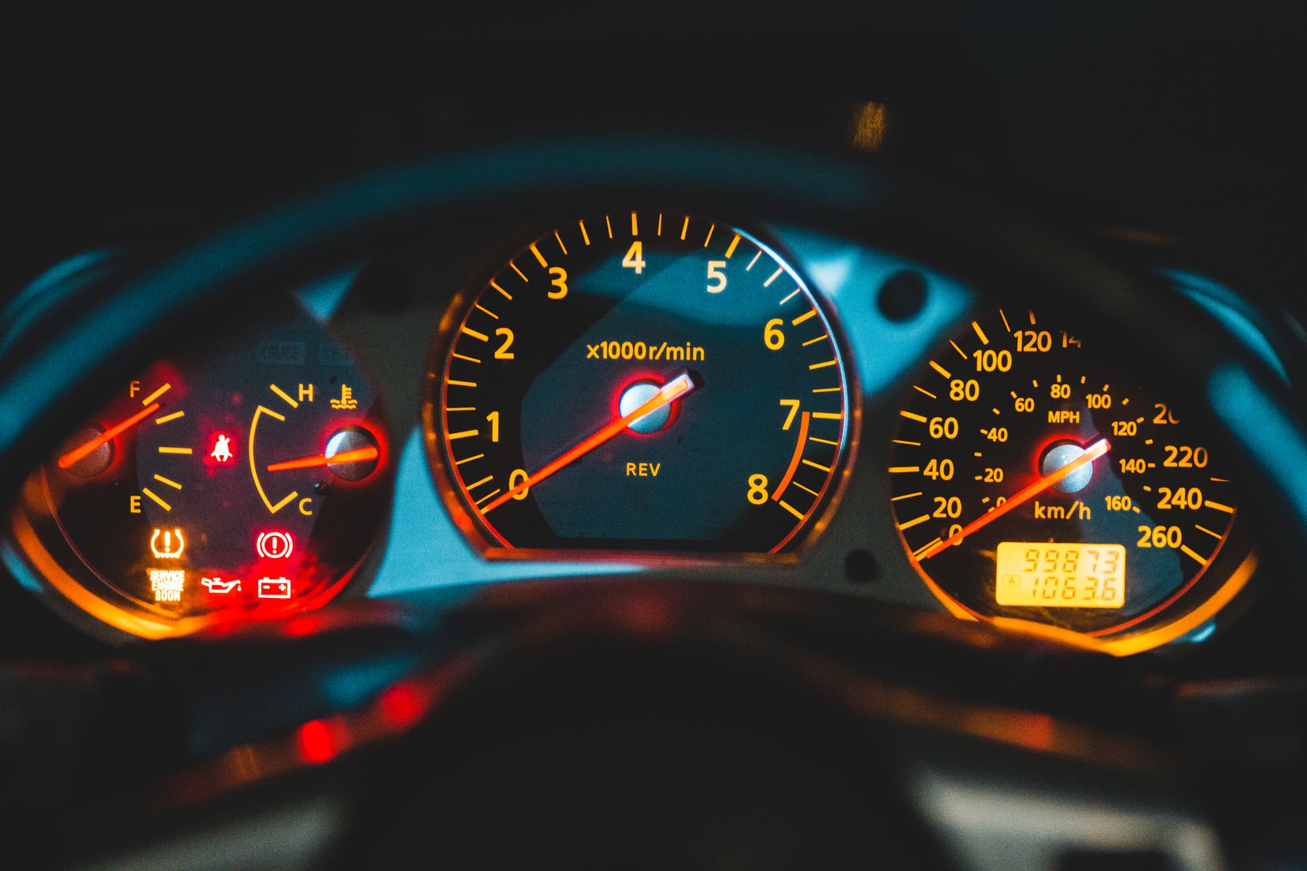 Painel de instrumentos de um carro iluminado à noite